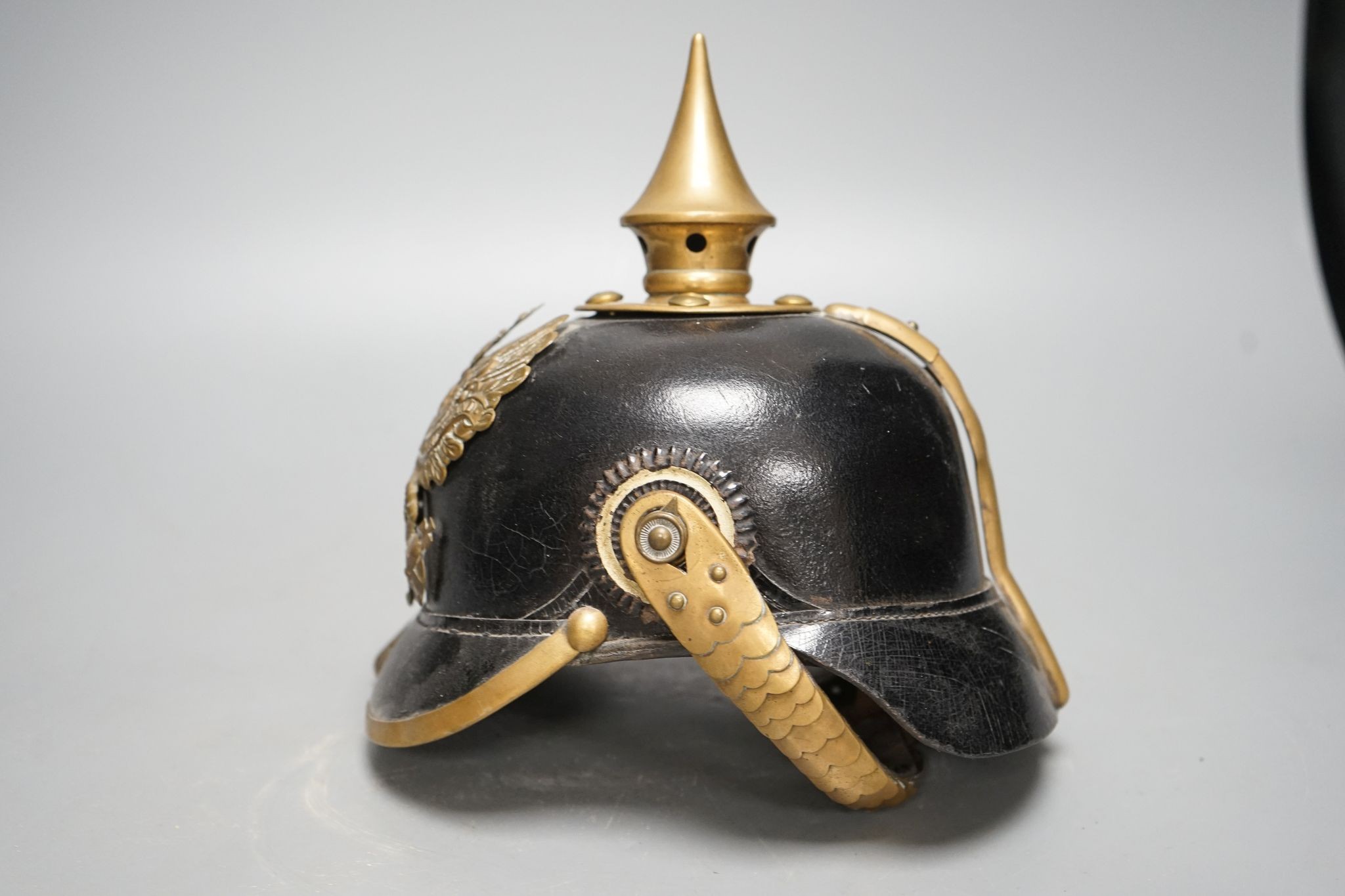 A WW1 Prussian pickelhaube, the leather skull with brass spiked top and eagle plate